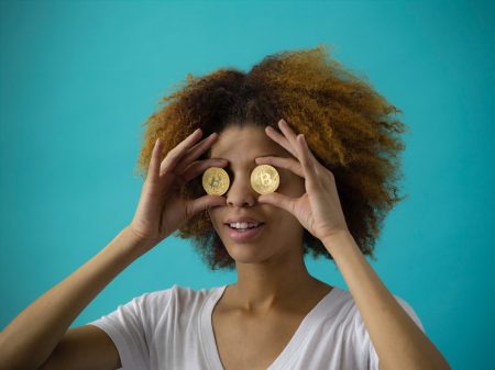 woman holding two round gold-colored coins