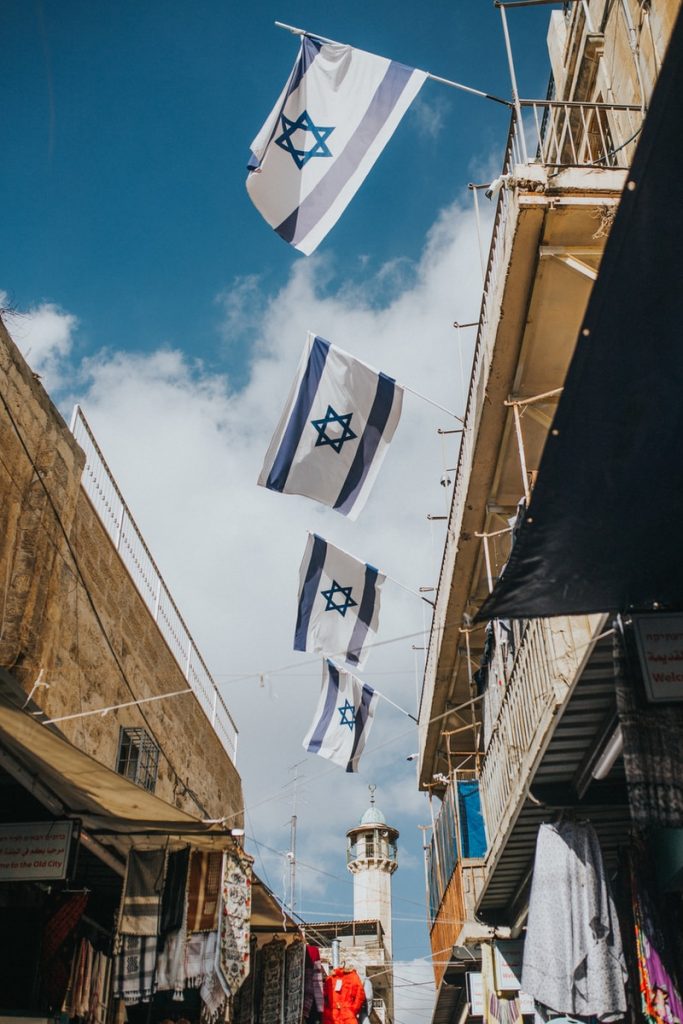 Governo de Israel inicia testes para moeda digital própria, usando tecnologia da Ethereum flags hanging on roof during daytime