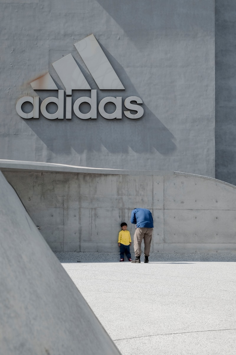 Homem e menino em frente a logo da Adidas (Henry & Co.)