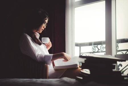Mulher na janela lendo livro (Anthony Tran)